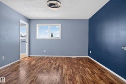 Wood-finish flooring, white window trim, white baseboards, and a ceiling-mounted light fixture - 