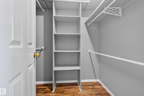 Built-in shelving unit providing storage, multiple clothing rods, and wood-finish flooring - 13803 130A Avenue Nw, Edmonton, AB 