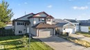 Two-story residence featuring light-colored siding, a two-car garage, and a sloped driveway - 13803 130A Avenue Nw, Edmonton, AB 