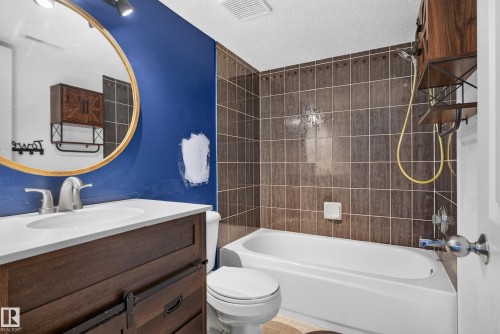 Dark wood-finish vanity with a white countertop and undermount sink - 13803 130A Avenue Nw, Edmonton, AB 