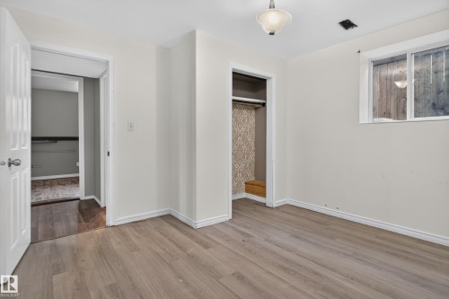 Wood-finish flooring, white trim, recessed closet, and an overhead light fixture - 13803 130A Avenue Nw, Edmonton, AB 