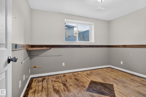 Wood-finish flooring with an accent inlay, complete with a window and a built-in shelf - 13803 130A Avenue Nw, Edmonton, AB 