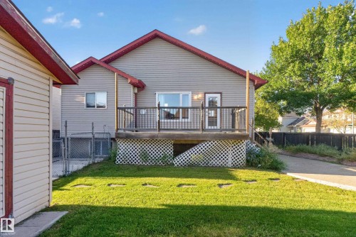 Rear exterior featuring a wooden deck with dark railings, horizontal siding, and a gabled roofline - 13803 130A Avenue Nw, Edmonton, AB 
