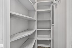 Built-in shelving with multiple levels, painted white finishes, and a corner configuration - 