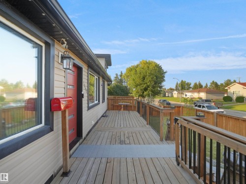 Expansive exterior deck featuring wood railing and black balusters - 13338 131 Street Nw, Edmonton, AB 