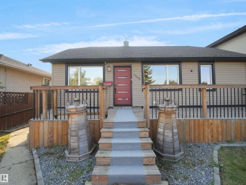 Front exterior featuring tan siding and a dark roof - 13338 131 Street Nw, Edmonton, AB 