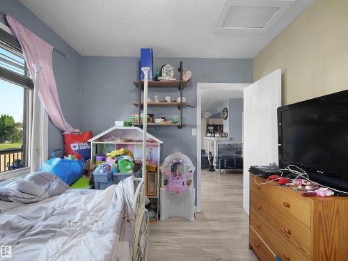 Wood-finish flooring throughout, with a window offering exterior views - 13338 131 Street Nw, Edmonton, AB 