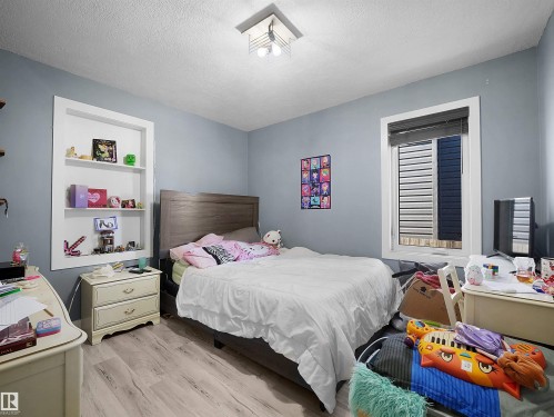 Built-in shelving, recessed window, wood-finish flooring, and a flush mount lighting fixture - 13338 131 Street Nw, Edmonton, AB 