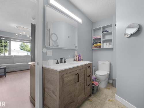 Vanity with wood-finish cabinetry, white countertop, and black hardware - 13338 131 Street Nw, Edmonton, AB 