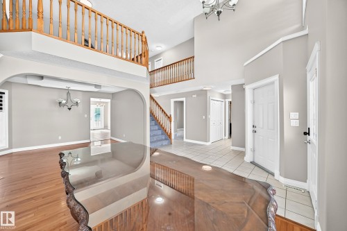 Two-story foyer with a vaulted ceiling, wood-finish flooring, and a tiled entryway - 4711 152 Avenue Nw, Edmonton, AB 