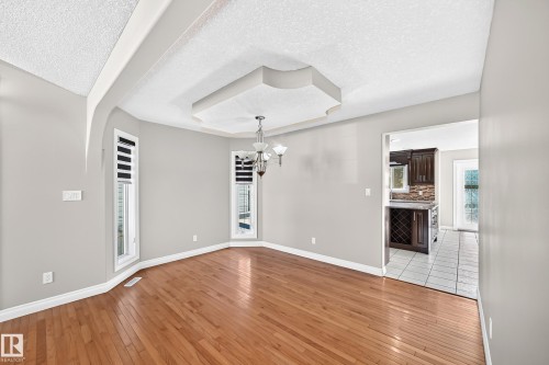 Hardwood-finish flooring, recessed ceiling feature, chandelier lighting, and a bay window - 4711 152 Avenue Nw, Edmonton, AB 