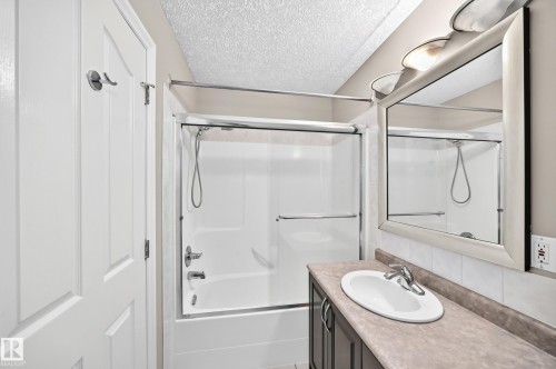White shower-tub combination with sliding glass doors - 4711 152 Avenue Nw, Edmonton, AB 
