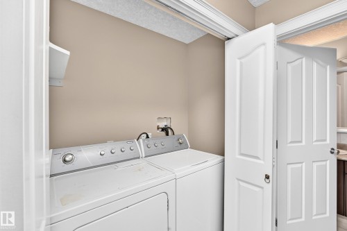 Laundry area with built-in shelving, bifold doors, and a neutral wall finish - 4711 152 Avenue Nw, Edmonton, AB 