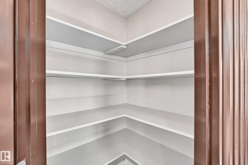 Built-in pantry shelving with multiple levels of white shelving - 4711 152 Avenue Nw, Edmonton, AB 