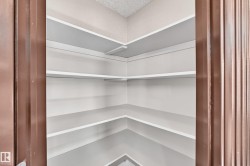 Built-in pantry shelving with multiple levels of white shelving - 