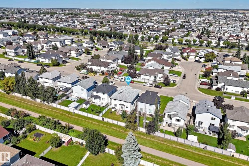 Residential neighborhood with a grid pattern, featuring multiple single-family homes with pitched roofs, individual driveways, and landscaped yards - 4711 152 Avenue Nw, Edmonton, AB 
