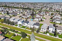 Residential neighborhood with a grid pattern, featuring multiple single-family homes with pitched roofs, individual driveways, and landscaped yards - 