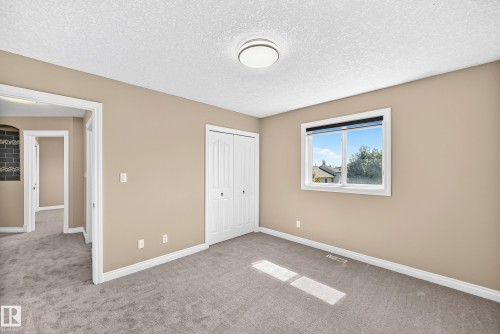 Neutral-toned walls complement the gray carpeting - 4711 152 Avenue Nw, Edmonton, AB 