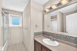 Vanity with integrated sink, mosaic tile backsplash, and mounted mirror - 