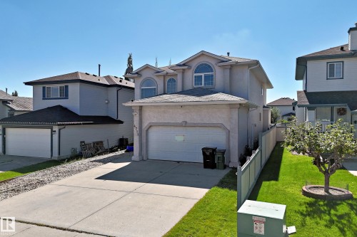Stucco exterior with arched windows, attached two-car garage, and a concrete driveway - 4711 152 Avenue Nw, Edmonton, AB 