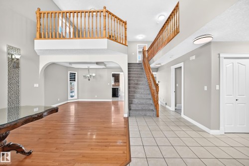 Hardwood flooring, tiled entry, carpeted staircase, open-concept archway, and recessed lighting - 4711 152 Avenue Nw, Edmonton, AB 