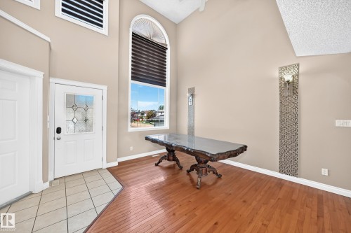 Vaulted ceiling, arched window, wood-finish flooring, tiled entry, and decorative wall sconces - 4711 152 Avenue Nw, Edmonton, AB 