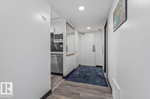 Wood-finish flooring throughout, with recessed lighting and a built-in mirror with a wood frame - #906 12303 Jasper Av Nw, Edmonton, AB 