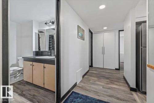 Bathroom featuring a single vanity with a dark countertop and a wall-mounted light fixture - #906 12303 Jasper Av Nw, Edmonton, AB 