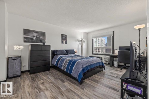 Wood-finish flooring throughout, white wall paint, and a window with roller shade - #906 12303 Jasper Av Nw, Edmonton, AB 