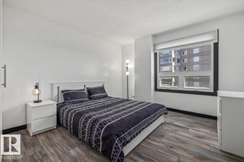 Wood-finish flooring, white walls, and a large window with roller shades - #906 12303 Jasper Av Nw, Edmonton, AB 