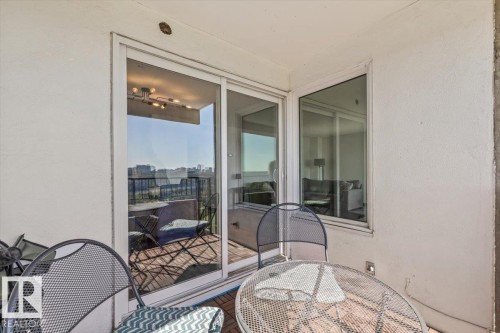 Private balcony featuring a tile-patterned floor, white stucco walls, and sliding glass doors - #906 12303 Jasper Av Nw, Edmonton, AB 