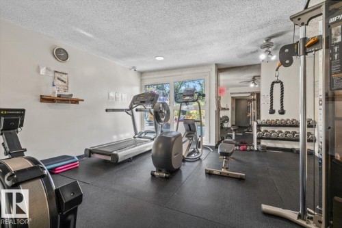 Recreational room with rubberized flooring, recessed lighting, and a mirrored accent wall - #906 12303 Jasper Av Nw, Edmonton, AB 