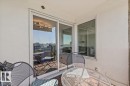 Private balcony featuring a tile-patterned floor, white stucco walls, and sliding glass doors - #906 12303 Jasper Av Nw, Edmonton, AB 
