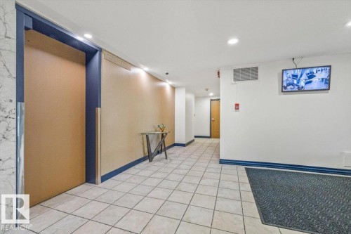 Tiled flooring, recessed ceiling lighting, wall-mounted display, and a built-in fire alarm system - #906 12303 Jasper Av Nw, Edmonton, AB 