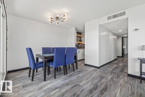 Wood-finish flooring throughout, modern ceiling light fixture, recessed lighting, built-in shelving, and white cabinetry - #906 12303 Jasper Av Nw, Edmonton, AB 
