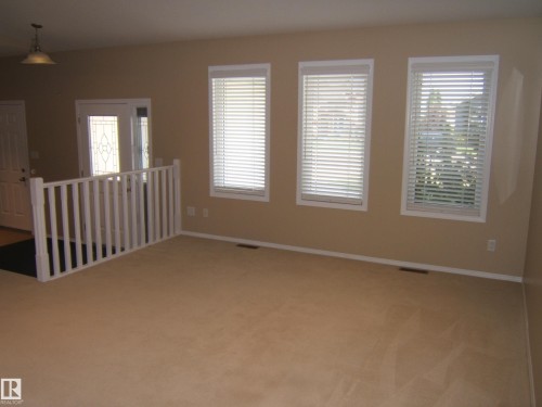 Light-toned wall paint, multiple windows with white blinds, and white trim throughout - 4825 59 Avenue, Vegreville, AB 