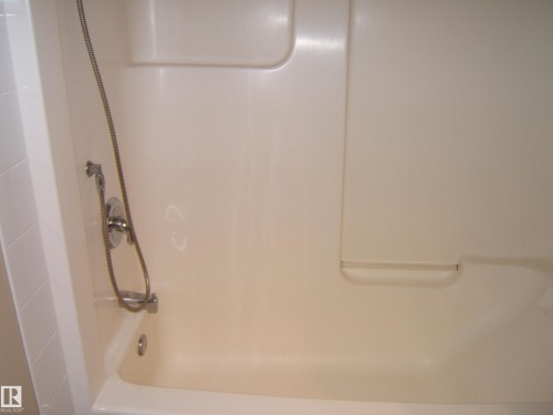 Integrated tub and shower combination with chrome fixtures and a handheld showerhead - 4825 59 Avenue, Vegreville, AB 