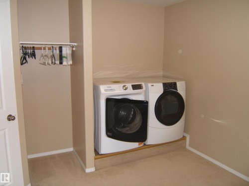 Dedicated laundry area with carpet flooring and a built-in hanging rod - 4825 59 Avenue, Vegreville, AB 