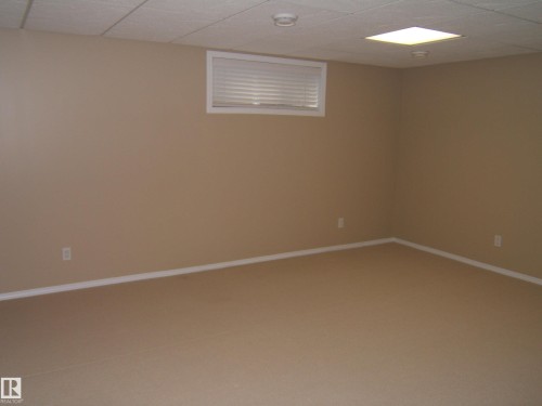 Warm neutral wall color, white trim, window with blinds, recessed ceiling lighting, and textile flooring - 4825 59 Avenue, Vegreville, AB 