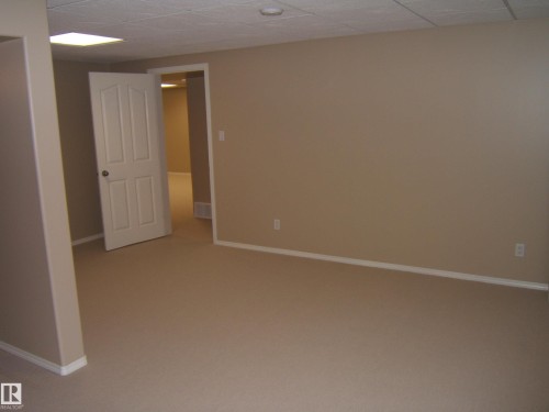 Neutral tone wall finishes, white trim, recessed lighting, and a paneled interior door - 4825 59 Avenue, Vegreville, AB 