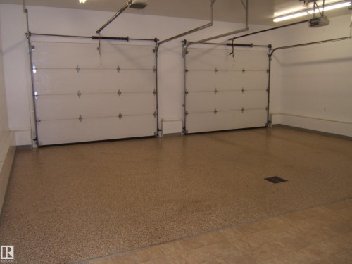 Two white sectional garage doors with panel detailing - 4825 59 Avenue, Vegreville, AB 