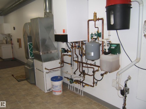 Utility area featuring HVAC system, extensive copper plumbing, and tile flooring - 4825 59 Avenue, Vegreville, AB 