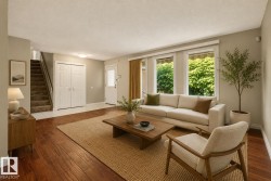 Hardwood flooring throughout the living area, white trim, and light-colored walls - 