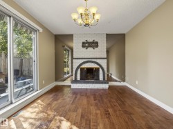 Elegant living space anchored by a striking arched fireplace with white brick surround and dark wood mantel - 