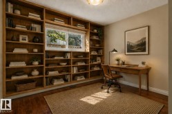 Built-in shelving, hardwood flooring, natural light through a window, a desk with drawers, and a ceiling-mounted light fixture - 