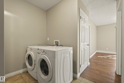 Dedicated laundry area with tile flooring and a neutral color palette - 