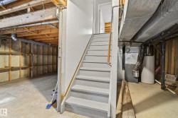Unfinished basement with concrete flooring and exposed ceiling joists - 