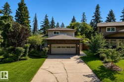 Modern two-story residence showcasing a brick exterior, two-car garage with paneled doors, and a concrete driveway - 