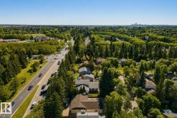 Aerial view showcasing this residential property nestled within mature landscaping and evergreen trees - 