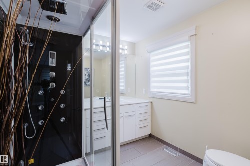 Contemporary shower enclosure featuring a black panel system with multiple body jets and an overhead rain shower - 14814 104 Avenue Nw, Edmonton, AB - Indoor